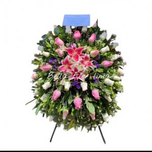 Lagrima en parante con lirios rosados, rosas blancas y rosadas, y follaje verde.